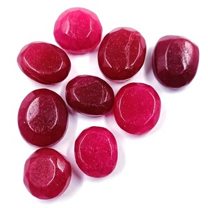 May include: A group of ten red and pink candy shaped like gemstones. The candies are on a white background.
