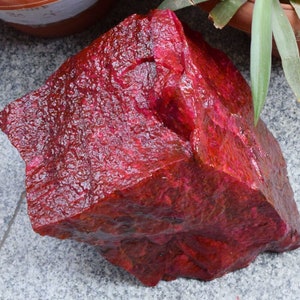 Puede incluir: Una gran gema de rubí rojo sin pulir. El rubí es de un color rojo intenso y rico y tiene una superficie natural sin pulir.