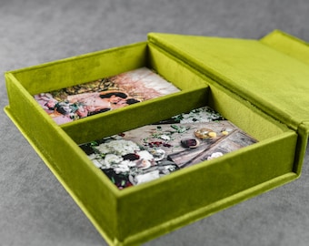 May include: A green velvet box with two compartments, each containing a photograph. The top compartment shows a couple in a garden setting, while the bottom compartment shows a floral arrangement on a wooden surface.