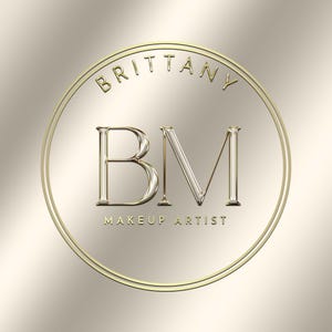 May include: Gold circular logo with the text "Brittany" and "Makeup Artist" around the outside. The initials "BM" are in the center of the logo.