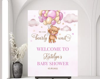 May include: Pink and gold baby shower welcome sign with a teddy bear holding pink and gold balloons. The sign says "We can bearly wait" and "Welcome to Katelyn's Baby Shower 07.18.2025".