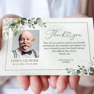 Peut inclure: Une carte de remerciement blanche avec une bordure florale verte. La carte contient une photo d'un homme avec une moustache et un n&oelig;ud papillon. Le texte sur la carte dit "Merci" et "Il n'y a pas de mots pour exprimer notre gratitude pour la sympathie et le soutien que vous avez t&eacute;moign&eacute;s &agrave; notre famille pendant cette p&eacute;riode difficile de deuil. Merci !" La famille de Robert.