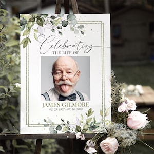 Peut inclure: Une pancarte comm&eacute;morative blanche avec une bordure florale verte et des accents dor&eacute;s. La pancarte indique "Celebrating the Life of James Gilmore 09.23.1952 - 07.16.2030". Une photo de James Gilmore est au centre de la pancarte.