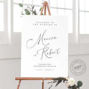 May include: A white wedding welcome sign with the text "Welcome to the wedding of Monica + Robert" and the date "07.16.2030" and location "Orlando, FL". The sign is on an easel with flowers in the foreground.