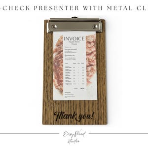Op de afbeelding: Houten checkpresenter met een metalen clip met een factuur. De factuur bevat tekst en een afbeelding van voedsel. De woorden "Thank you!" staan op het houten oppervlak gedrukt. De checkpresenter is van Easy Wood Studio.
