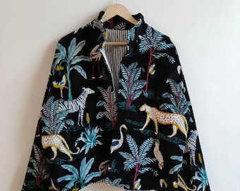 Könnte beinhalten: Schwarze Jacke mit einem lebendigen Dschungel-Print mit Zebras, Leoparden und tropischen Pflanzen. Die Jacke hat einen hohen Kragen und ein gestreiftes Futter, das an einem Holzbügel hängt.
