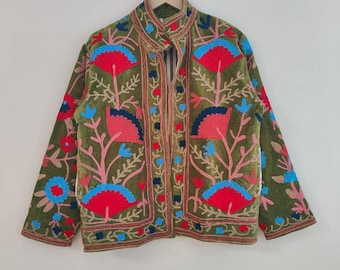 May include: Olive green jacket with intricate floral embroidery in red, pink, and blue. The jacket features a mandarin collar and is displayed on a hanger. The embroidery details are visible on the sleeves and front panels.