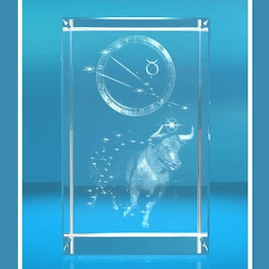 Op de afbeelding: Een transparante glazen briefgewicht met een 3D-geëtst ontwerp van het sterrenbeeld Stier en een stier. Het sterrenbeeld is omgeven door een cirkel met Romeinse cijfers en het symbool voor Stier.