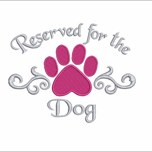 May include: A white background with a silver embroidered design that says "Reserved for the Dog" with a pink paw print in the center.