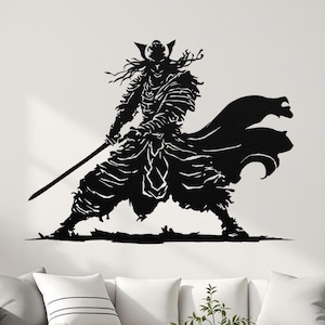 May include: Black metal wall art depicting a samurai warrior in a dynamic pose, holding a sword. The artwork features intricate details of the samurai's armor and flowing cape, creating a striking silhouette. The art is mounted on a white wall above a white sofa.