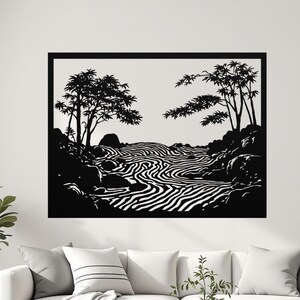 May include: Black and white wall art depicting a zen garden scene. The artwork features stylized trees, rocks, and a flowing river with a striped pattern. The art is framed in a black border and hangs above a white sofa.