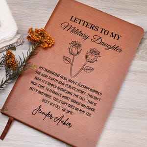 May include: A brown leather journal with the text "Letters to My Military Daughter" and a floral illustration. The journal includes a heartfelt message and the signature "Jennifer Aaker."