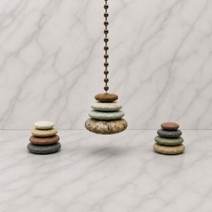 May include: A ceiling fan pull chain featuring a stack of four smooth, multi-colored stones in shades of brown, gray, and green. Two additional stacks of four stones each are positioned on either side, displaying varied natural textures and colors.