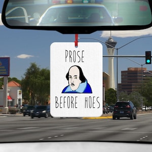 Könnte beinhalten: Weißer Auto-Lufterfrischer mit einem Cartoon-Bild von William Shakespeare und dem Text "Prose Before Hoes".