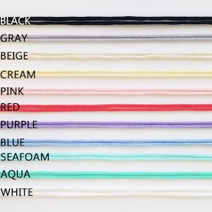 May include: A close-up of ten different colored cords, each labeled with a color name: black, gray, beige, cream, pink, red, purple, blue, seafoam, aqua, and white.