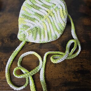 May include: A crocheted leaf-shaped bag with a white and green striped strap.