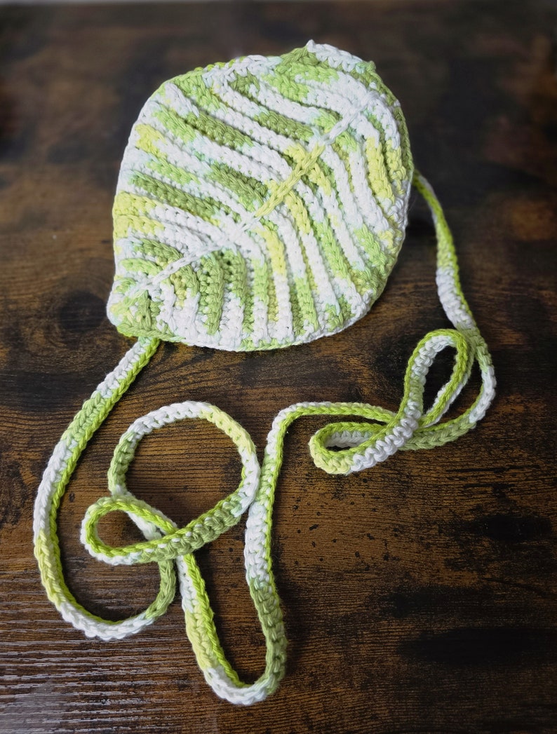 May include: A crocheted leaf-shaped bag with a white and green striped strap.