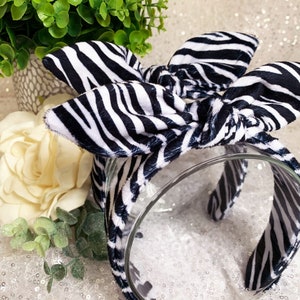 Peut inclure: Un serre-t&ecirc;te noir et blanc &agrave; imprim&eacute; z&egrave;bre avec un n&oelig;ud nou&eacute;. Le serre-t&ecirc;te est fait d'un tissu doux et est parfait pour ajouter une touche de style &agrave; n'importe quelle tenue.