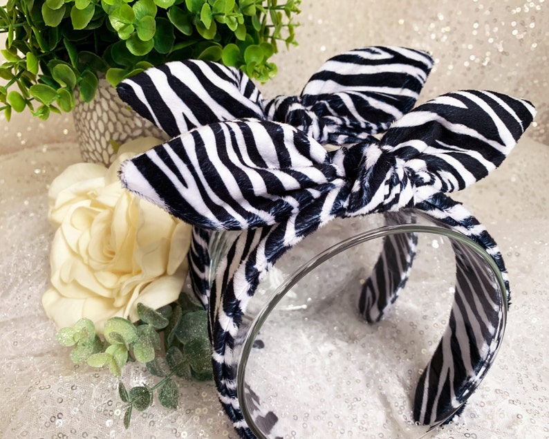 Peut inclure: Un serre-t&ecirc;te noir et blanc &agrave; imprim&eacute; z&egrave;bre avec un n&oelig;ud nou&eacute;. Le serre-t&ecirc;te est fait d'un tissu doux et est parfait pour ajouter une touche de style &agrave; n'importe quelle tenue.