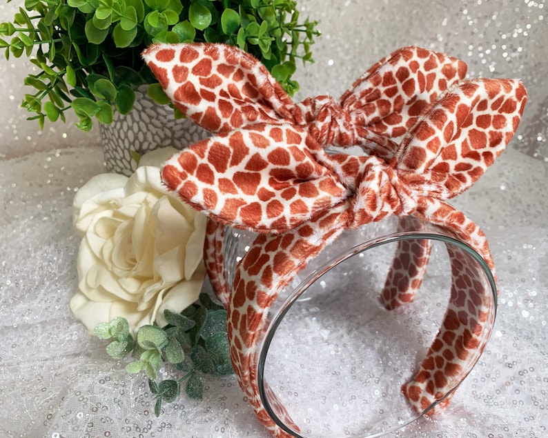 Peut inclure: Un serre-t&ecirc;te marron et blanc &agrave; motif avec un n&oelig;ud. Le serre-t&ecirc;te est fait d'un tissu doux et pelucheux et est parfait pour ajouter une touche de fantaisie &agrave; n'importe quelle tenue.
