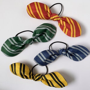 May include: Four striped fabric hair ties in red and yellow, green and white, blue and white, and yellow and black.