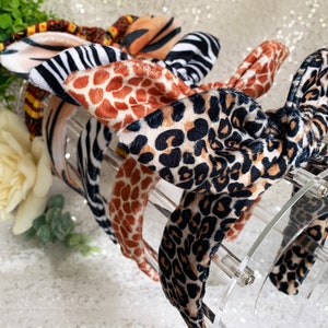 Peut inclure: Quatre bandeaux &agrave; n&oelig;ud diff&eacute;rents avec un motif nou&eacute;. Les bandeaux sont pr&eacute;sent&eacute;s sur un support en acrylique transparent. Les motifs comprennent des imprim&eacute;s z&egrave;bre, l&eacute;opard, girafe et tigre.