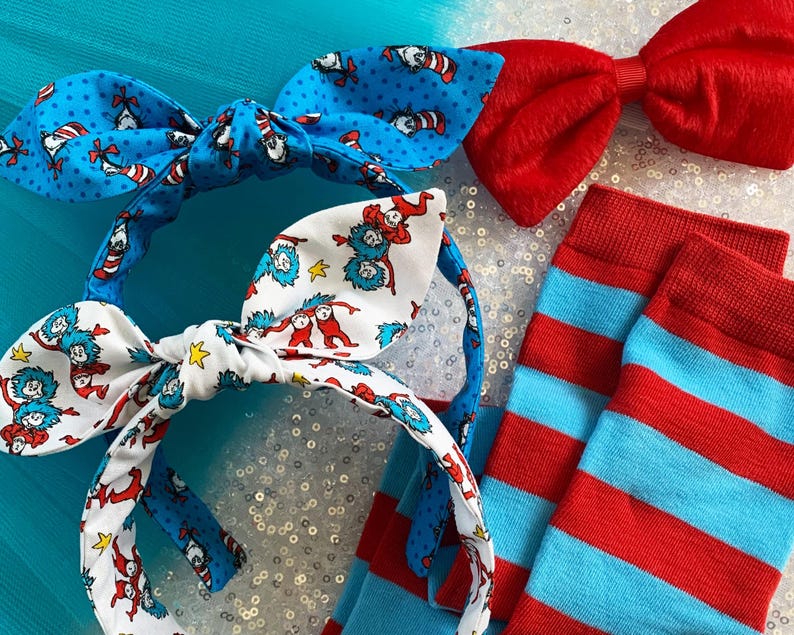 May include: Two red and blue striped headbands with a bow tie and a pair of red and blue striped socks. The headbands feature a pattern of the Cat in the Hat characters.