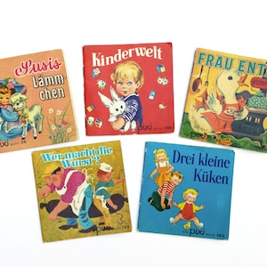 Op de afbeelding: Een verzameling van zes vintage kinderboeken met kleurrijke omslagen met illustraties van dieren en kinderen. De titels zijn "Susis Lämmchen", "Kinderwelt", "Frau Entes grosser Jag", "Wer macht die Wurst?", "Drei kleine Küken" en "Pixi Buch 140".