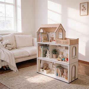 Könnte beinhalten: Ein dreistöckiges Puppenhaus-Bücherregal aus Holz mit einem hellen Holzdach und weißem Rahmen. Die Regale enthalten verschiedene Kinderbücher, Plüschbären, eine kleine Topfpflanze, eine Holzleiter und ein kleines Holzeisenbahn-Set auf der mittleren Ebene.