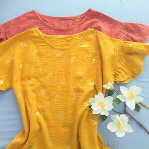 Blusa básica de mujer de muselina natural, gasa de algodón, con volantes y mangas cortas, estampado de hojas de terracota y mostaza, color amanecer.