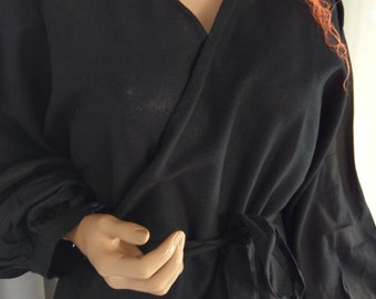 Klassisch-elegantes Mini-Wickelkleid aus Leinen in Schwarz mit bestickten Spitzendetails, Leinenkleid mit Puffärmeln in schwarzem Umschlag und Bindebändern.