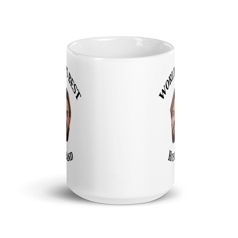 May include: White ceramic mug with a black and white image of a man's face and the text "World's Best Husband" on the mug.