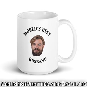 May include: White ceramic mug with a black inscription that reads "World's Best Husband". A man's face is in the center of the mug.