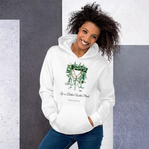 Puede incluir: Sudadera con capucha blanca con una ilustración de planta verde y el texto "Life is Better With Plants".