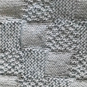 May include: A close-up of a knitted fabric with a geometric pattern in a light blue color.
