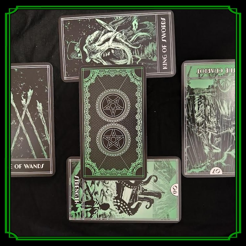 Op de afbeelding: Een spread van tarotkaarten met zwarte en groene illustraties. De kaarten tonen afbeeldingen van de Koning van Zwaarden, De Wagen, Kracht en de 8 van Staven. De achterkant van de kaarten heeft een pentagramontwerp.