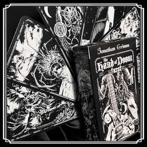 Peut inclure: Bo&icirc;te de jeu de cartes de tarot noir et blanc avec le titre "The Hand of Doom Tarot" et le nom "Jonathan Grimm". La bo&icirc;te pr&eacute;sente une illustration en noir et blanc d'une personne portant un masque &agrave; gaz et tenant une guitare.