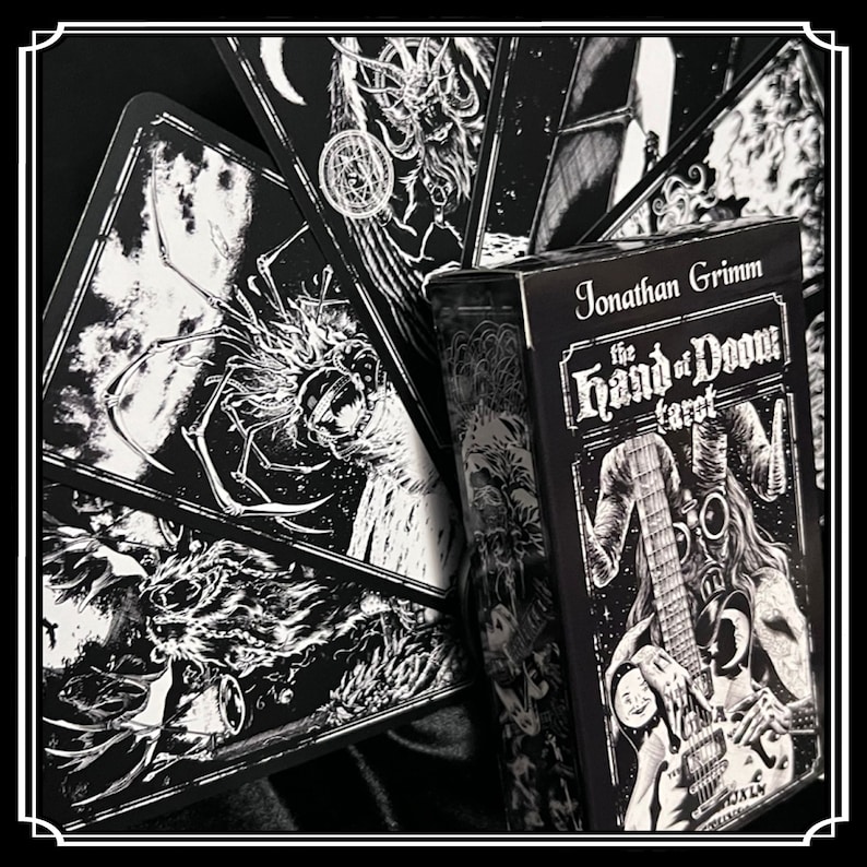 Peut inclure: Bo&icirc;te de jeu de cartes de tarot noir et blanc avec le titre "The Hand of Doom Tarot" et le nom "Jonathan Grimm". La bo&icirc;te pr&eacute;sente une illustration en noir et blanc d'une personne portant un masque &agrave; gaz et tenant une guitare.