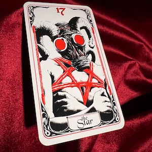 May include: A tarot card with a black and white illustration of a person wearing a gas mask with red horns and a red pentagram. The card is numbered 17 and titled "The Star".