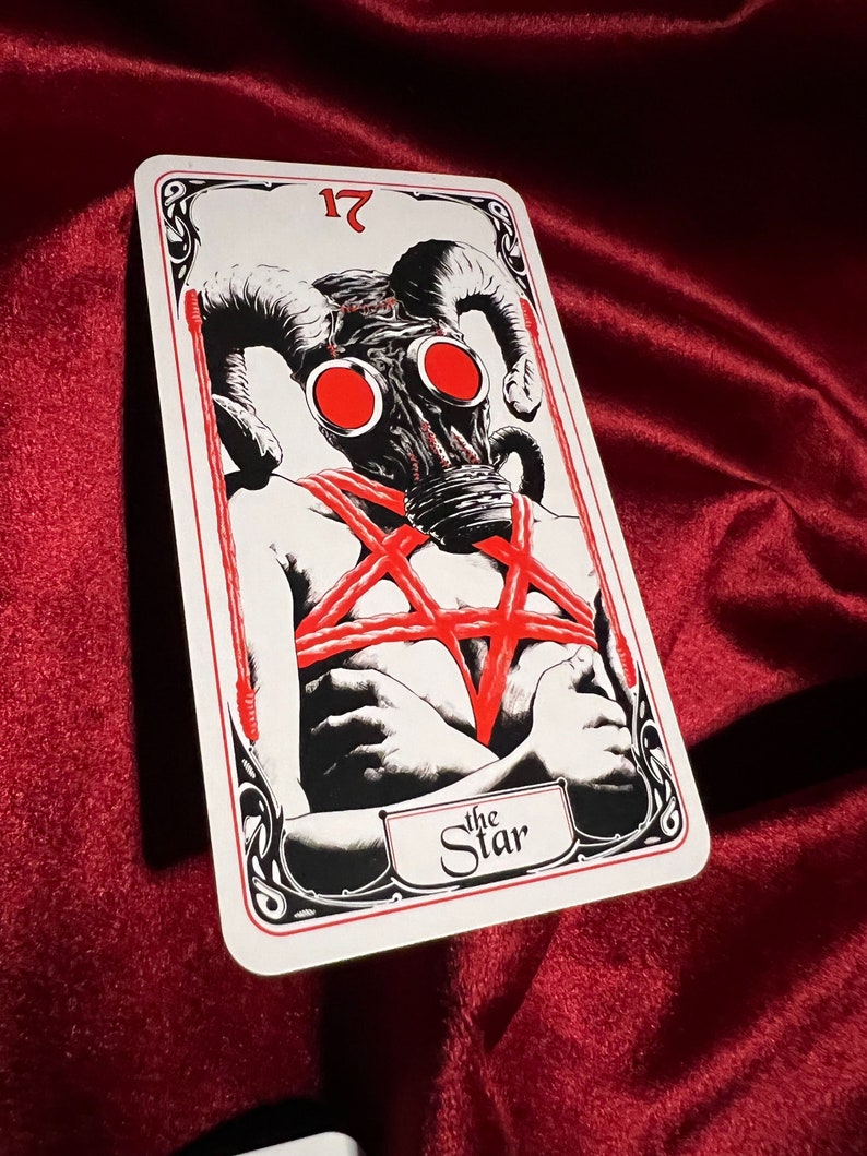 May include: A tarot card with a black and white illustration of a person wearing a gas mask with red horns and a red pentagram. The card is numbered 17 and titled "The Star".