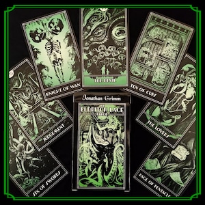 Op de afbeelding: Een tarotkaartspel met een zwart en groen ontwerp. De kaarten tonen illustraties en tekst, waaronder "De Duivel", "Ridder van Staven" en "Oordeel". Het spel heet "Eldritch Lace Tarot" van Jonathan Grimm.