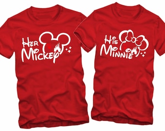 Könnte beinhalten: Zwei rote T-Shirts mit weißem Text und Grafiken. Das linke Shirt sagt "Her Mickey" mit einem Mickey Mouse Kopf und einer Silhouette von Schloss Aschenputtel. Das rechte Shirt sagt "His Minnie" mit einem Minnie Mouse Kopf und einer Silhouette von Schloss Aschenputtel.