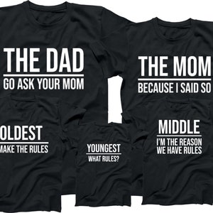 May include: Five black t-shirts with white text. The shirts read "The Dad Go Ask Your Mom", "The Mom Because I Said So", "Oldest I Make The Rules", "Youngest What Rules?", and "Middle I'm The Reason We Have Rules".
