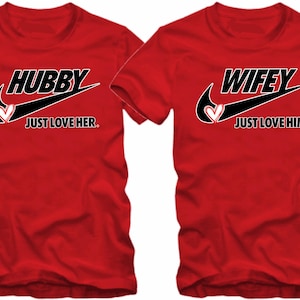 May include: Two red t-shirts with a black Nike swoosh and the words "Hubby Just Love Her." and "Wifey Just Love Him."