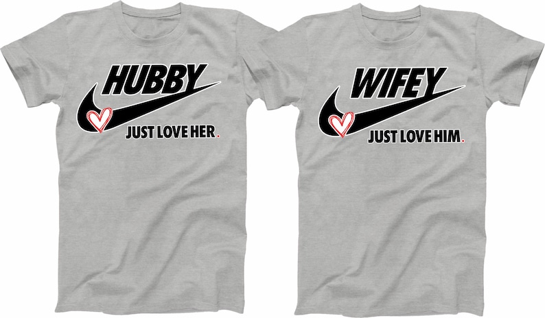 May include: Two grey t-shirts with a black Nike swoosh and a red heart. The left shirt says "Hubby Just Love Her." The right shirt says "Wifey Just Love Him."