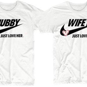 May include: Two white t-shirts with a black Nike swoosh and the words "Hubby Just Love Her." and "Wifey Just Love Him." printed on them.