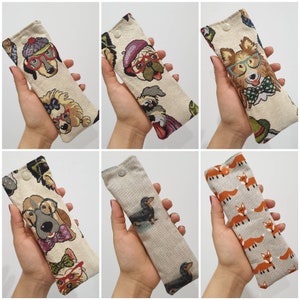 May include: Set of ten colourful eyeglass cases featuring various dog breeds with whimsical patterns. Each case is made of a soft, textured fabric and has a zipper closure.
