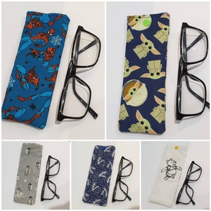 May include: Six different eyeglass cases with various patterns and colors. Each case is made of fabric and has a zipper closure. The cases are paired with black eyeglasses.