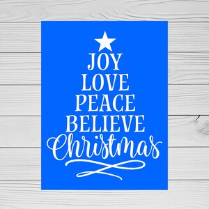 May include: A blue Christmas tree sign with white text that reads "Joy Love Peace Believe Christmas".