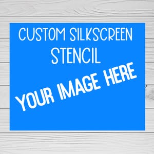 Peut inclure: Un rectangle bleu avec du texte blanc indiquant "CUSTOM SILKSCREEN STENCIL" et "YOUR IMAGE HERE". Le texte est de style manuscrit. Le fond est un grain de bois clair.
